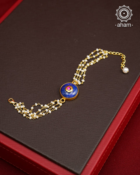 This Lapiz old Polish Silver Bracelet features a stunning green quartz with pink kundan inlay and delicate pearls. Ideal for family gatherings and festivities, this delicate bracelet will add a touch of elegance to any outfit. Hand-crafted with care in silver with gold polish, it's the perfect accessory for any occasion.