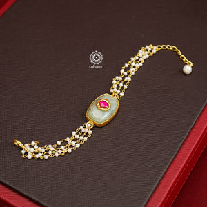 This Green Quartz Gold Polish Silver Bracelet features a stunning green quartz with pink kundan inlay and delicate pearls. Ideal for family gatherings and festivities, this delicate bracelet will add a touch of elegance to any outfit. Hand-crafted with care in silver with gold polish, it's the perfect accessory for any occasion.