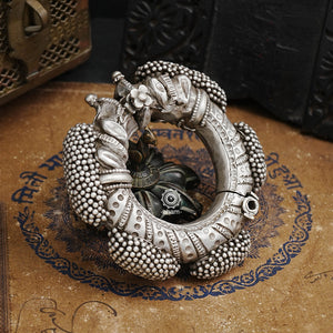A true Catalogue rare piece. One of its kind.  A two part, openable Nogri or Gajredar Bangri with Central Makara heads.  The bracelet is heavy and almost 221 grams,  ornamented with bunched hollow balls (gajre) rigidly fixed to the main body by threading a wire through their attached integral loops.   ORIGIN: RAJASTHAN