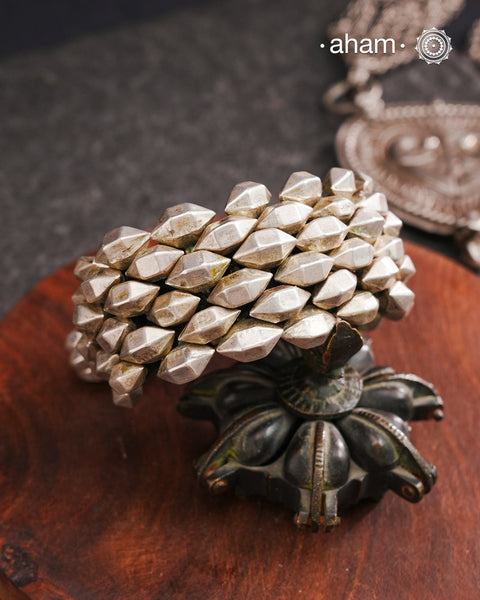 Tribal pauchi with silver bead work, handcrafted by skilful artisans. Also known as lahsan ki Pahunchian, (Each representing a clove of garlic) Many single bead units are closely strung on a black cotoon cord, this piece has 6 parallel rows. closed with end loop and ball.  Beautiful handcuff from a bygone era, that bring back memories and stories of that time