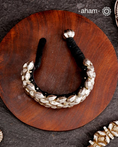 Tribal pauchi with silver bead work, handcrafted by skilful artisans. Also known as lahsan ki Pahunchian, (Each representing a clove of garlic) Many single bead units are closely strung on a black cotoon cord, this piece has 6 parallel rows. closed with end loop and ball.  Beautiful handcuff from a bygone era, that bring back memories and stories of that time