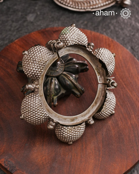 Vintage silver kada with intricate work, handcrafted by skilful artisans. Beautiful piece from a bygone era, that bring back memories and stories of that time. The Naugari Kada is a Two part bracelet with projected simulated gajre balls made from stamped silver sheet.