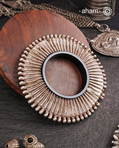 Vintage Silver Kada from Rajasthan. Beautiful piece from a bygone era, that bring back memories and stories of that time. Comes with a plastic bangle inside. Super light. Works great for stacking. Originally a arm piece.it is the bangle in the front that the model is wearing in the image.the samller of the two kadas