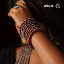 Beautiful tribal silver Bangles. Perfectly crafted silver flowers set on red plastic bangles. Comes as a set of 2 Bangles.