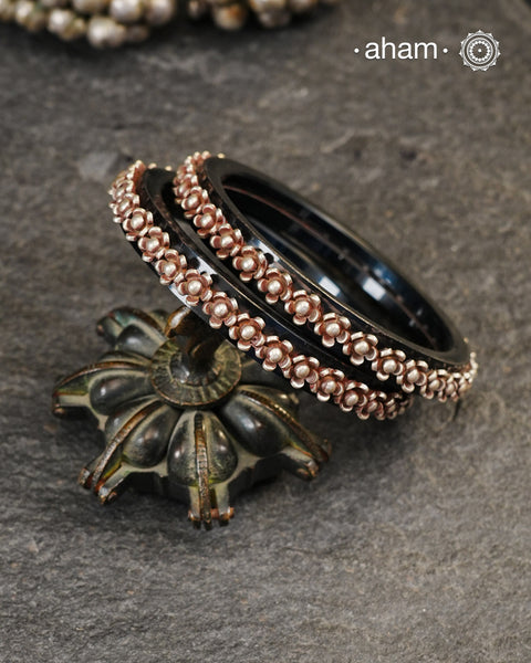 Beautiful tribal silver Bangles. Perfectly crafted silver flowers set on Black plastic bangles. Comes as a set of 2 Bangles