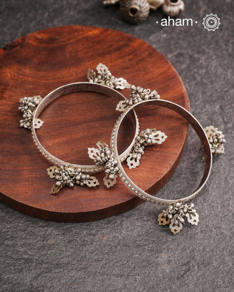 Celebrate Navratri with these expertly crafted tribal silver bangles, featuring delicate trinklets that add a rhythmic charm to your traditional attire. They offer a comfortable fit while enhancing your festive look with authentic tribal elegance. Perfect for those who appreciate handcrafted silver jewellery with cultural significance.