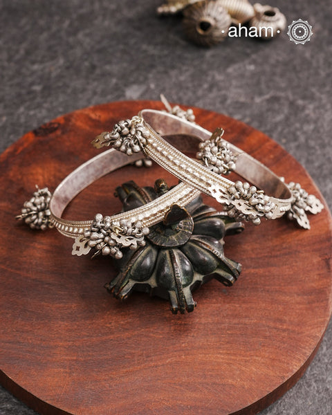 Celebrate Navratri with these expertly crafted tribal silver bangles, featuring delicate trinklets that add a rhythmic charm to your traditional attire. They offer a comfortable fit while enhancing your festive look with authentic tribal elegance. Perfect for those who appreciate handcrafted silver jewellery with cultural significance.