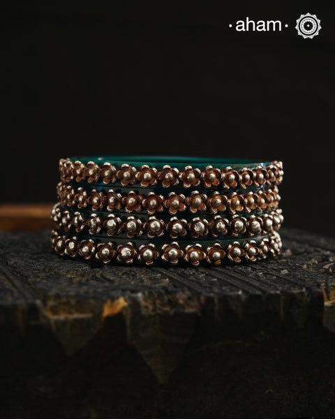 Beautiful tribal silver Bangles. Perfectly crafted silver flowers set on green plastic bangles. Comes as a set of 2 Bangles.AVAILABLE ON PREORDER BASIS