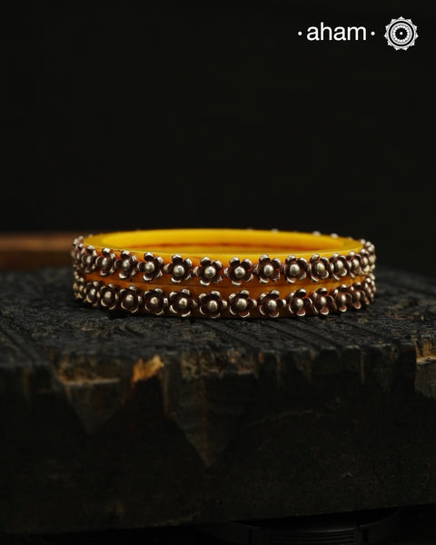 Beautiful tribal silver Bangles. Perfectly crafted silver flowers set on green plastic bangles. Comes as a set of 2 Bangles. AVAILABLE ON PREORDER BASIS