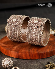Vintage silver kada with rava and tar work handcrafted by skilful artisans. Beautiful piece from a bygone era, that bring back memories and stories of that time.
Price is for a pair. Incase you wish to buy a single piece please get in touch at 8884445300
