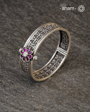 This handcrafted bangle showcases the exceptional skill of Kolhapur's master karigars, created entirely from 92.5 sterling silver with striking kemp stone accents.The bangle demonstrates superior craftsmanship through its precise construction and refined finish. Kemp highlights add textural depth and visual interest to the classic kada silhouette. An investment piece that honours traditional jewellery-making heritage while offering versatile styling for both formal occasions and daily adornment.
