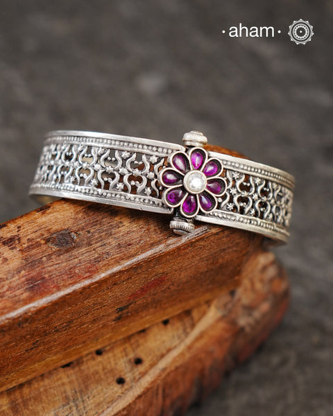 This handcrafted bangle showcases the exceptional skill of Kolhapur's master karigars, created entirely from 92.5 sterling silver with striking kemp stone accents.The bangle demonstrates superior craftsmanship through its precise construction and refined finish. Kemp highlights add textural depth and visual interest to the classic kada silhouette. An investment piece that honours traditional jewellery-making heritage while offering versatile styling for both formal occasions and daily adornment.