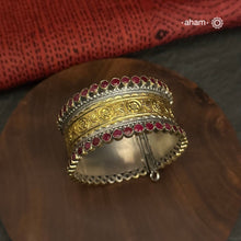 The Noori Two Tone Silver Cuff is a versatile addition to any wardrobe. Its solid silver design is accented with a striking gold tone band and maroon stones, creating a stunning combination. This cuff is openable and available in a size 2.5, making it a perfect fit for any individual. Elevate your style with this dual tone classic piece.
The price is for one piece kada only. 

