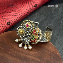 Noori two tone silver open hand cuff with a vibrant Peacock motif. An eclectic mix of elements, with a play of colours, textures, forms and workmanship. Handcrafted in 92.5 Sterling Silver with two tones that make them so versatile and unique. Modern Heirloom pieces that can be worn across generations. 
The price is for one piece kada only. 

