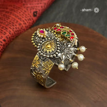 Noori two tone silver open hand cuff with a vibrant Peacock motif. An eclectic mix of elements, with a play of colours, textures, forms and workmanship. Handcrafted in 92.5 Sterling Silver with two tones that make them so versatile and unique. Modern Heirloom pieces that can be worn across generations. 
The price is for one piece kada only. 

