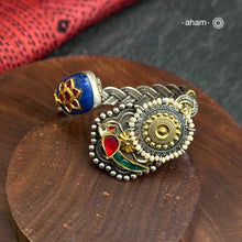 This Noori Two Tone Lapiz Stone Silver Cuff is a work of art. The braided cuff features a lapiz stone with kundan inlay on one side and a red green bird on the other, creating a classic dual tone design. Expertly crafted, this cuff is a stunning addition to any jewelry collection.
The price is for one piece kada only. 

