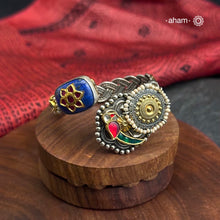 This Noori Two Tone Lapiz Stone Silver Cuff is a work of art. The braided cuff features a lapiz stone with kundan inlay on one side and a red green bird on the other, creating a classic dual tone design. Expertly crafted, this cuff is a stunning addition to any jewelry collection.
The price is for one piece kada only. 

