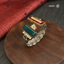 Introducing the Noori Two Tone Silver Cuff, a beautifully crafted open cuff in 92.5 silver featuring a two-tone braided band adorned with stunning green and pink kundan and parrot designs. Elevate your style with this unique and elegant piece, perfect for any occasion.

The price is for one piece kada only.