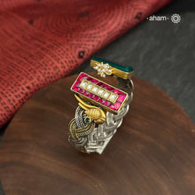 Introducing the Noori Two Tone Silver Cuff, a beautifully crafted open cuff in 92.5 silver featuring a two-tone braided band adorned with stunning green and pink kundan and parrot designs. Elevate your style with this unique and elegant piece, perfect for any occasion.

The price is for one piece kada only.