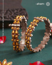 Enhance your style with the timeless elegance of the Dual Tone Silver Kada. Handcrafted by skilled karigars in Barmer, Rajasthan, this earring features traditional Bandhel work, where a thin sheet of hand beaten 22 carat gold is set on 92.5 silver using a unique wax setting technique. A classic representation of fine Indian craftsmanship.