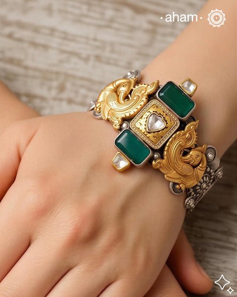 Noori two tone silver open hand cuff with a vibrant peacock motif. An eclectic mix of elements, with a play of colours, textures, forms and workmanship. Handcrafted in 92.5 Sterling Silver with two tones that make them so versatile and unique. Modern Heirloom pieces that can be worn across generations.&nbsp;
