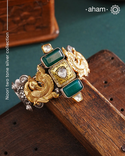 Noori two tone silver open hand cuff with a vibrant peacock motif. An eclectic mix of elements, with a play of colours, textures, forms and workmanship. Handcrafted in 92.5 Sterling Silver with two tones that make them so versatile and unique. Modern Heirloom pieces that can be worn across generations.
The price is for one piece kada only.