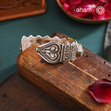 This unique Noori Two Tone Silver Hand Cuff (Open Cuff) is handcrafted using 92.5 silver, featuring a beautiful mother of pearl center and intricately carved green onyx on the sides. Truly a statement piece of wearable art.


The price is for one piece kada only.