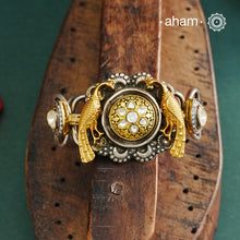 The Noori Two Tone Peacock Silver Cuff showcases expert craftsmanship in 92.5 sterling silver, featuring a distinctive blend of two-tone hues and a Victorian finish. Its intricate textures and elegant forms create a versatile accessory that complements both contemporary and classic styles, making it a unique statement piece for any collection.