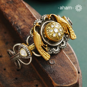 The Noori Two Tone Peacock Silver Cuff showcases expert craftsmanship in 92.5 sterling silver, featuring a distinctive blend of two-tone hues and a Victorian finish. Its intricate textures and elegant forms create a versatile accessory that complements both contemporary and classic styles, making it a unique statement piece for any collection.