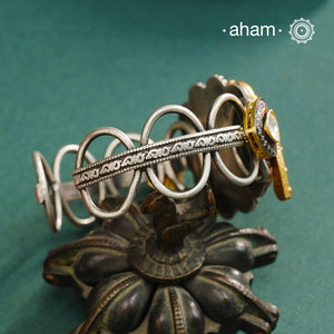 The Noori Two Tone Peacock Silver Cuff showcases expert craftsmanship in 92.5 sterling silver, featuring a distinctive blend of two-tone hues and a Victorian finish. Its intricate textures and elegant forms create a versatile accessory that complements both contemporary and classic styles, making it a unique statement piece for any collection.