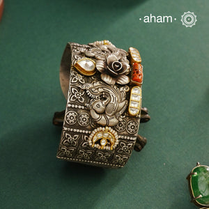 Noori hand cuff with a play of colours, textures, forms and workmanship. Crafted in 92.5 Sterling Silver with two tones, coral and kundan that make them so versatile and unique.