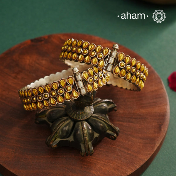 Enhance your style with the timeless elegance of the Dual Tone Silver Kada. Handcrafted by skilled karigars in Barmer, Rajasthan, this earring features traditional Bandhel work, where a thin sheet of hand beaten&nbsp;22 carat gold is set on 92.5 silver using a unique wax setting technique. A classic representation of fine Indian craftsmanship.
Comes as a pair.