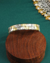 Elevate your wrist game with this striking two-tone hand cuff, masterfully crafted to bridge traditional and contemporary aesthetics. The intricate weave pattern showcases the artistry of handcrafted silver work, while the interplay of gold and silver tones adds sophisticated depth. Versatile enough to complement your ethnic ensembles or modern Western wardrobe, this statement piece transitions seamlessly from day to evening wear. A timeless investment for those who appreciate refined craftsmanship and unde
