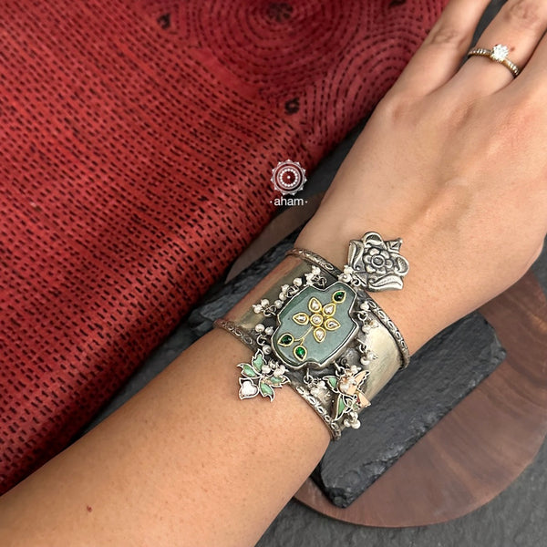 Introducing the Ira Silver HandCuff, a bold statement piece that exudes confidence. Made from 92.5 silver, it features stunning green onyx with intricate kundan inlay work and delicate pearls. Perfect for minimal accessorizing while still making a statement. Let your wrists do the talking with this chic and unique cuff.