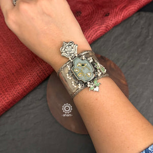 Introducing the Ira Silver HandCuff, a bold statement piece that exudes confidence. Made from 92.5 silver, it features stunning jade with intricate kundan inlay work and delicate pearls. Perfect for minimal accessorizing while still making a statement. Let your wrists do the talking with this chic and unique cuff.