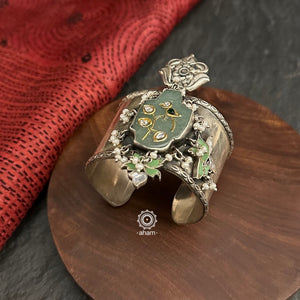 Introducing the Ira Silver HandCuff, a bold statement piece that exudes confidence. Made from 92.5 silver, it features stunning jade with intricate kundan inlay work and delicate pearls. Perfect for minimal accessorizing while still making a statement. Let your wrists do the talking with this chic and unique cuff.