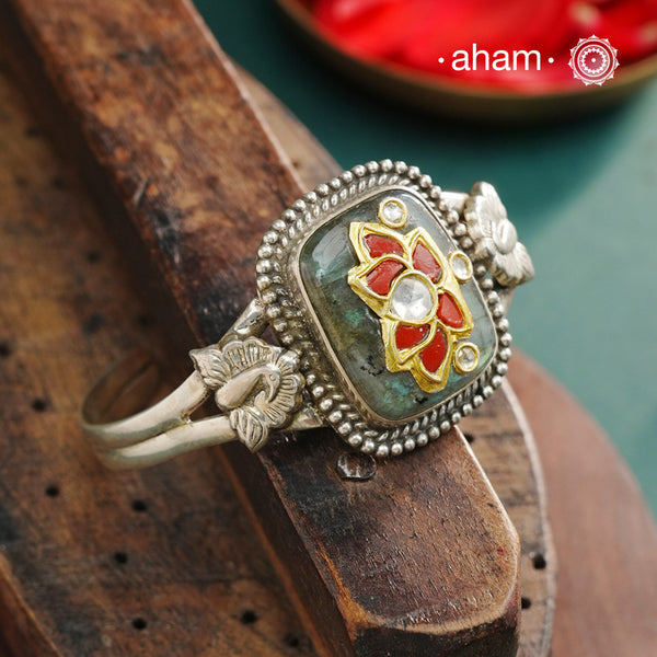 The Ira Lotus Silver Hand Cuff showcases a delicate lotus motif adorned with kundan stones, set on a captivating labradorite stone. Handmade in 92.5 silver, this elegant cuff complements any style—whether worn solo for a subtle statement or stacked alongside your watch and other bracelets for a layered, sophisticated look. Its expert craftsmanship ensures both beauty and lasting quality.