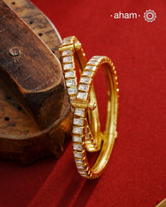 A set of 2 Moissanite kadas that are expertly crafted from 92.5% sterling silver with fine gold polish finish, showcasing a refined and elegant appearance. They are beautifully set with brilliant moissanite stones that closely mimic the sparkle of real diamonds, adding exceptional brilliance. The openable size 2.4 design offers a comfortable and adjustable fit, making this piece a sophisticated addition to any jewellery collection.