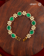 Handcrafted in 92.5 silver with a gold polish finish, this elegant bracelet features dazzling moissanite stones, floral motifs, and vibrant green accents. A timeless statement piece designed to elevate festive, wedding, and occasion wear.