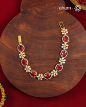 Handcrafted in 92.5 silver with a gold polish finish, this elegant bracelet features dazzling moissanite stones, floral motifs, and vibrant red accents. A timeless statement piece designed to elevate festive, wedding, and occasion wear.