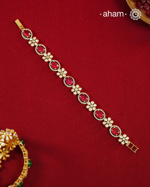 Handcrafted in 92.5 silver with a gold polish finish, this elegant bracelet features dazzling moissanite stones, floral motifs, and vibrant red accents. A timeless statement piece designed to elevate festive, wedding, and occasion wear.