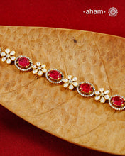 Handcrafted in 92.5 silver with a gold polish finish, this elegant bracelet features dazzling moissanite stones, floral motifs, and vibrant red accents. A timeless statement piece designed to elevate festive, wedding, and occasion wear.