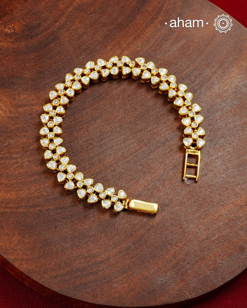 Handcrafted in 92.5 silver with a gold polish finish, this elegant tennis bracelet features dazzling moissanite stones and floral motifs. A timeless statement piece designed to elevate festive, wedding, and occasion wear.
The price is for one piece only.&nbsp;