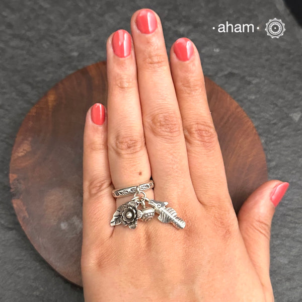 Adjustable Ring in 92.5 sterling silver with different charms.Perfect piece to add a playful tough to your look.