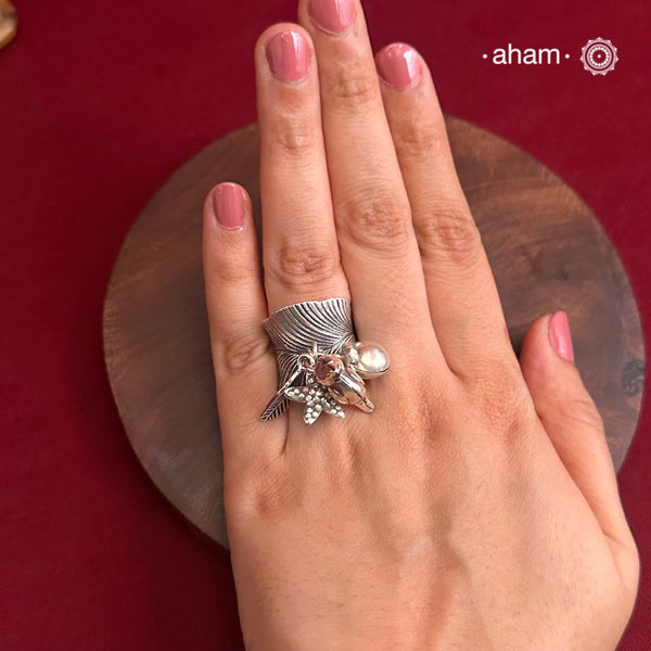 Adjustable Ring in 92.5 sterling silver with different charms.Perfect piece to add a playful tough to your look.