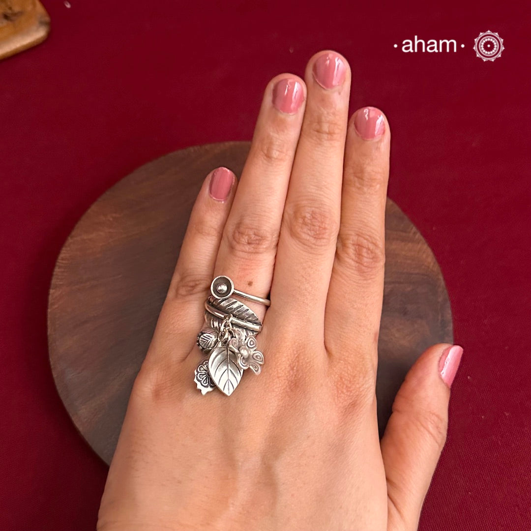 Adjustable Ring in 92.5 sterling silver with different charms.Perfect piece to add a playful tough to your look.