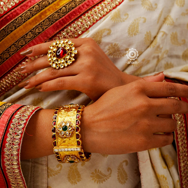 Gold polish adjustable ring with kundan stone setting. Handcrafted in 92.5 sterling silver with red semi precious stone drop. Perfect for special occasions and festivities. 