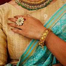 Festive gold polish adjustable ring kundan stone setting. Handcrafted in 92.5 sterling silver with elegant floral work including green coloured centre. Perfect for special occasions and festivities. 