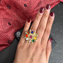 Festive gold polish adjustable ring with Navratna Stone setting, kundan and pearl highlights. Handcrafted in 92.5 silver. Perfect for special occasions and festivities. 