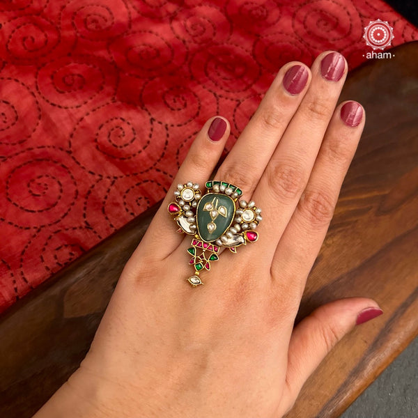 Crafted in 92.5 silver and dipped in gold polish, the Kundan Gold Polish Silver Ring features a beautiful festive design with stone inlay work, kundan setting, and delicate pearls. Perfect for adding an elegant touch to any festive occasion.